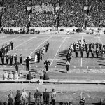 The Million Dollar Band on the football field, forming the letters "U" and "A."
