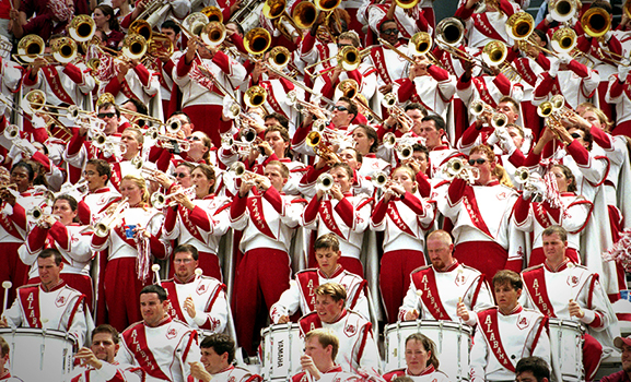 A large group of band members, mid-performance.