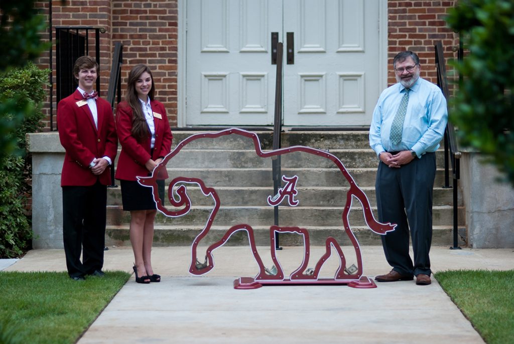 Dean Olin and two students with elephant-shaped Plexiglas bank