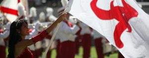 a colorguard member holds a crimson and white flag