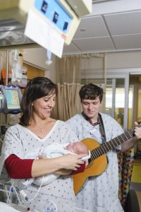 Andrea Cevasco-Trotter sings to a premature baby with one of her students.