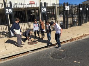 Students looking at drainage outside of the Bryant-Denny stadium. 