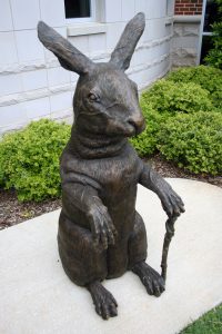 Bronze sculpture of a rabbit holding a cane
