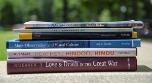 stack of books written by faculty and one alumnus