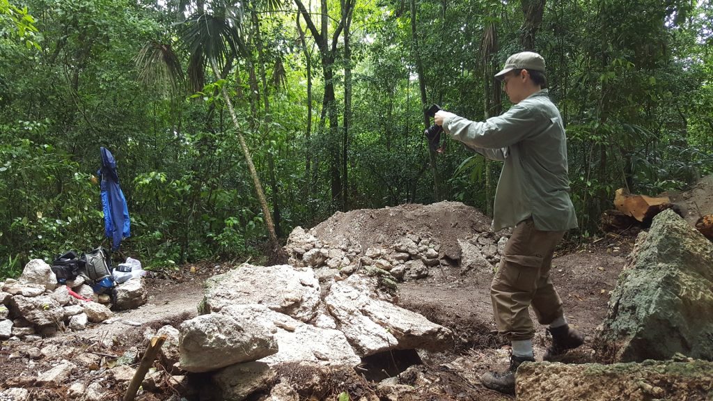 Alexandre Tokovinine photographing broken fragments of a Mayan monument