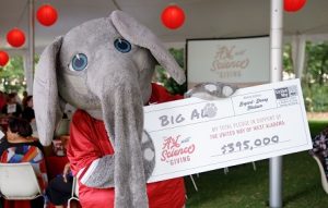 Big Al holds a big cardboard check for $395,000 for the United Way campaign