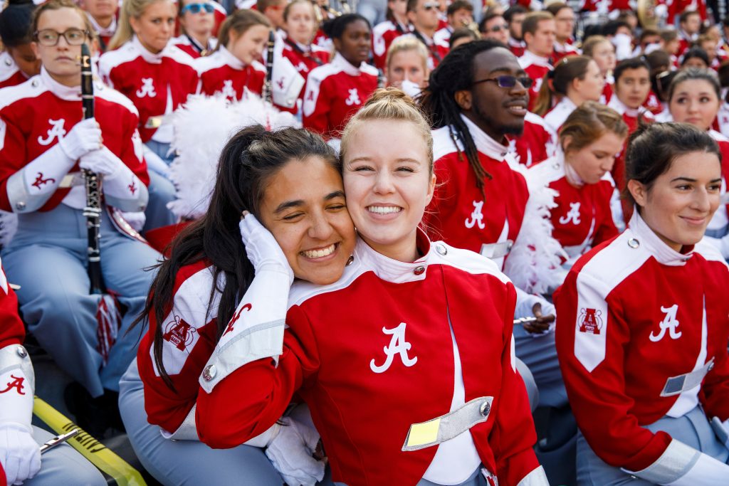 Members of the Million Dollar Band pose in the stands of Bryant-Denny at a football game.