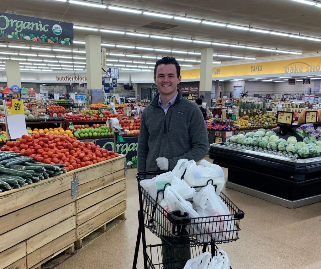 Michael Arundel with a cart of bagged groceries in the grocery store.