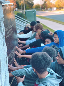 Students touch a memorial in Montgomery