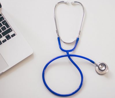 stethoscope next to a laptop