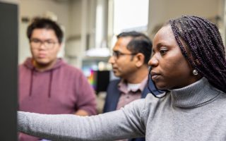 Graduate student Catherine Asagwegbe Obaze works in the precision timing lab of Dr. Thejesh Bandi, center, alongside graduate student Hung Lam.