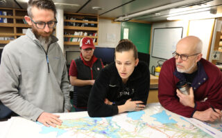 Alastair Graham, Victoria Fitzgerald, Rebecca Totten, and Robert Larter looking at a map