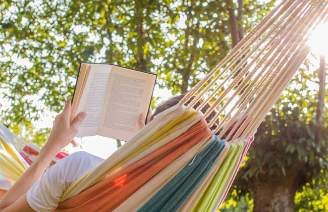 person reading a book in a hammock